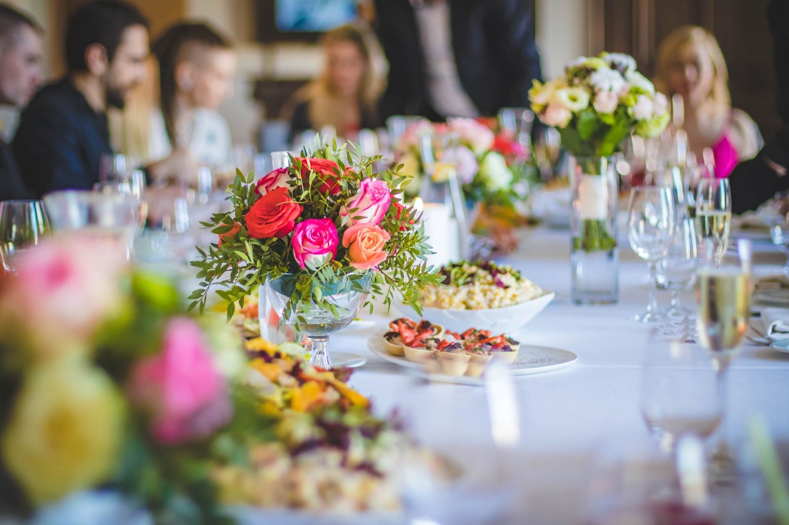 Beautifully set dining table with vibrant floral arrangements and elegant tableware.