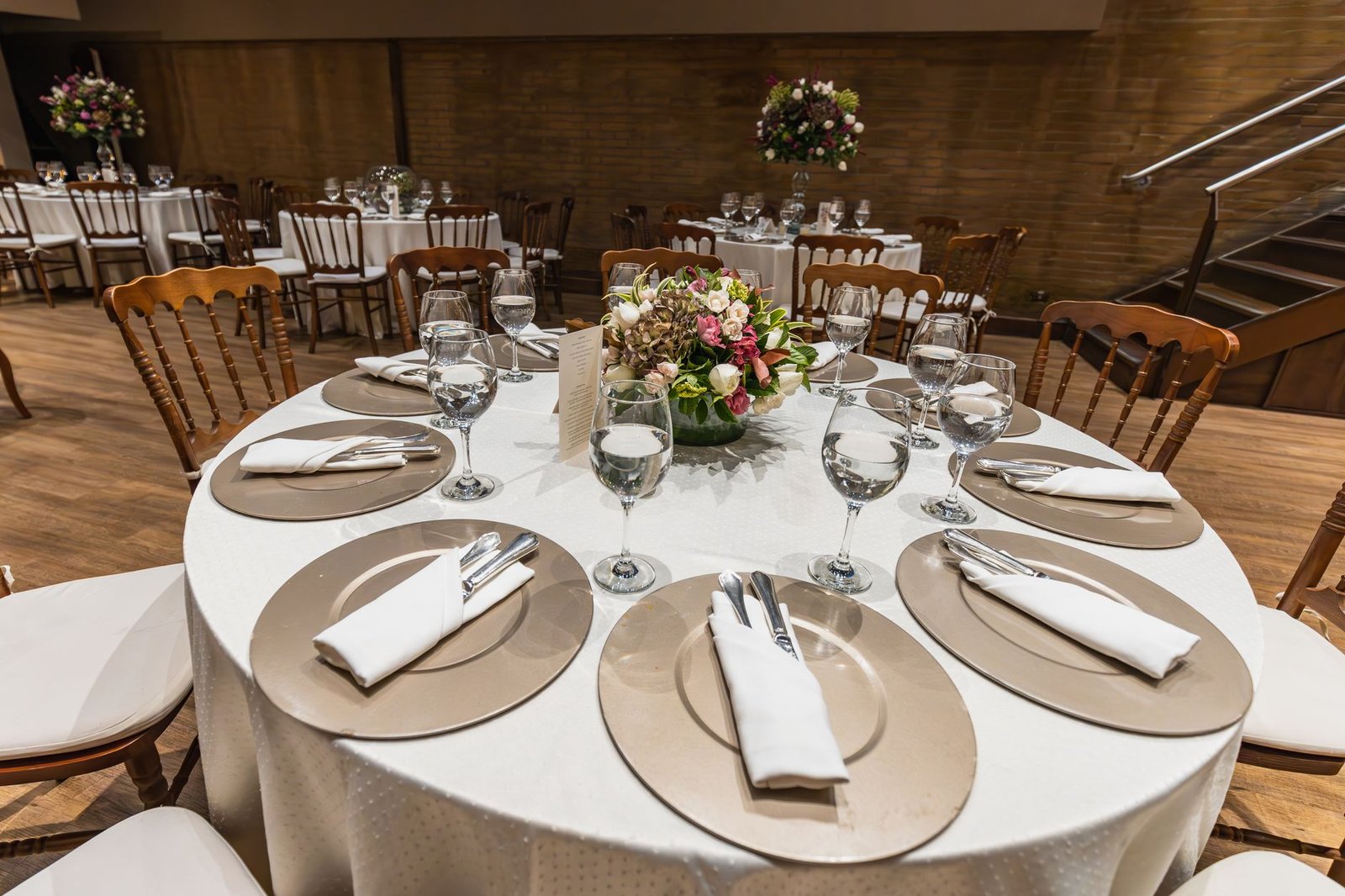 Luxurious table setting for a wedding reception with elegant tableware and floral centerpiece.