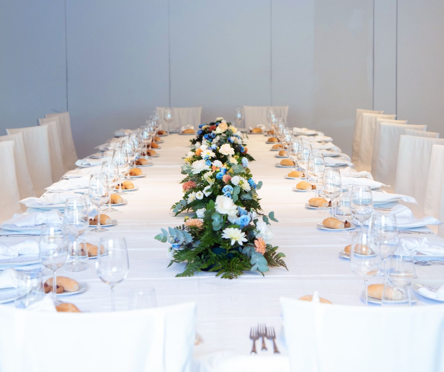 Luxurious banquet table setting with a vibrant floral centerpiece, ready for an elegant indoor event.
