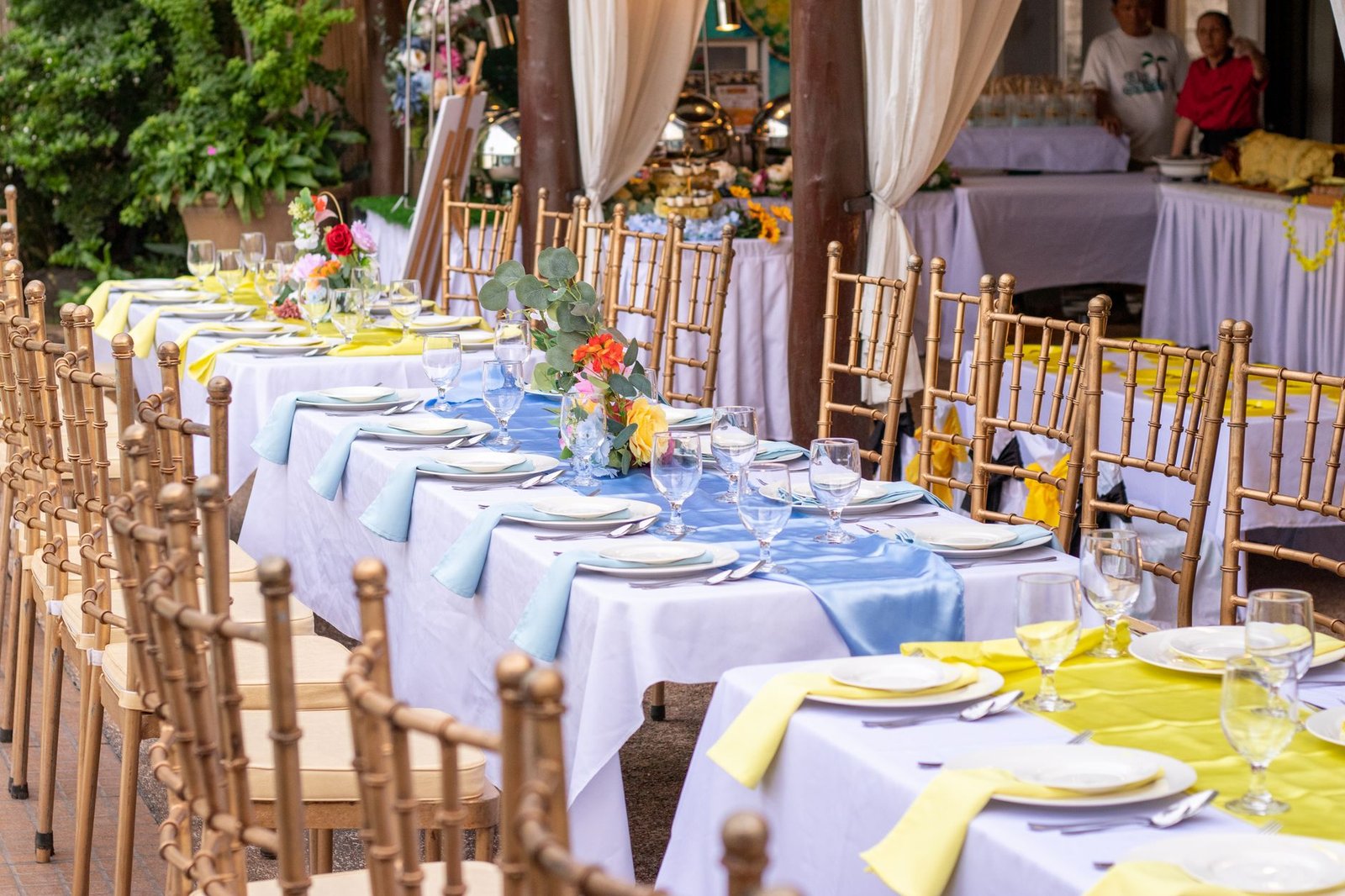 Beautifully arranged outdoor dining tables with colorful decor for an elegant gathering.