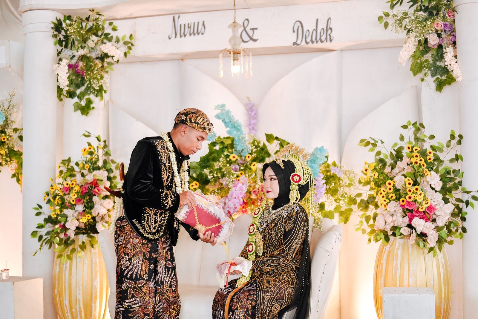 Upacara pernikahan Jawa yang elegan menampilkan dekorasi bunga yang semarak dan pakaian tradisional.
