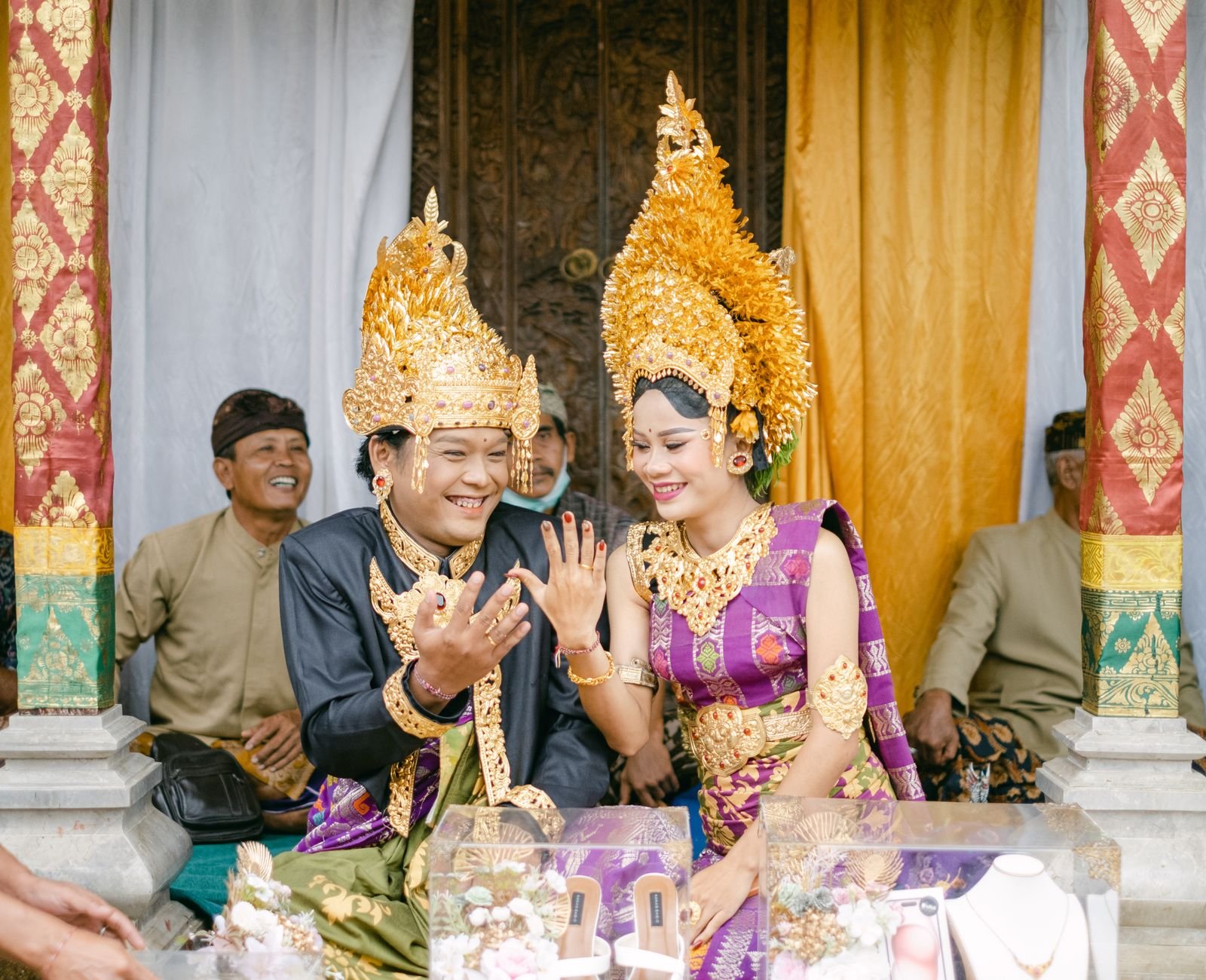 Pasangan Bali dengan pakaian adat merayakan pernikahan mereka dengan suka cita dan tawa.