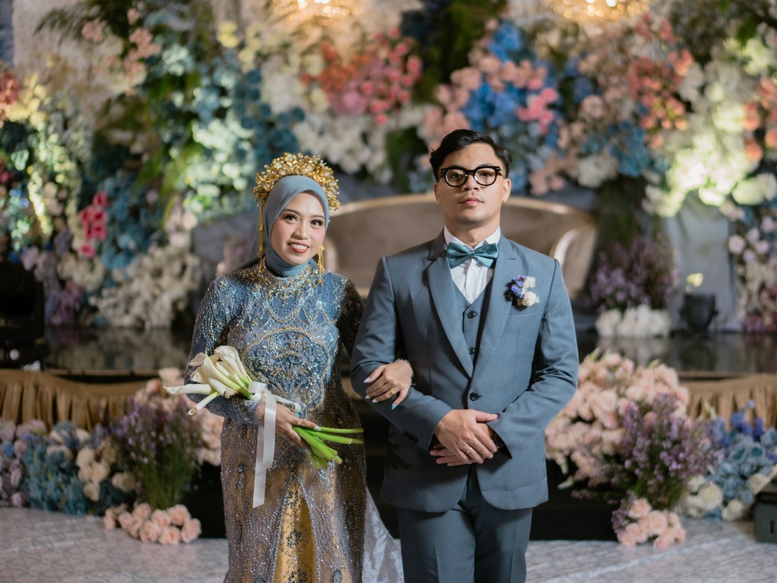 Sepasang pengantin baru mengenakan pakaian tradisional di sebuah pernikahan indah di Kendari, Indonesia.