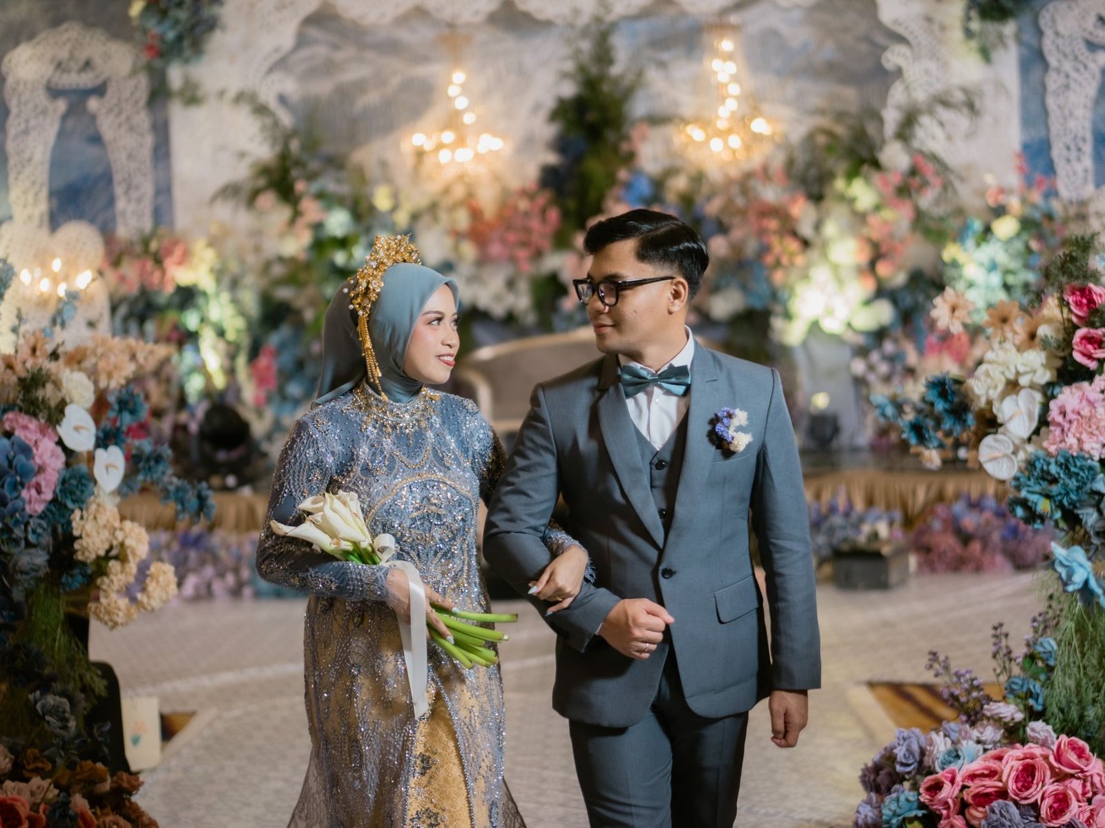 Pasangan Indonesia tampil elegan dalam balutan busana pesta pernikahan yang meriah.