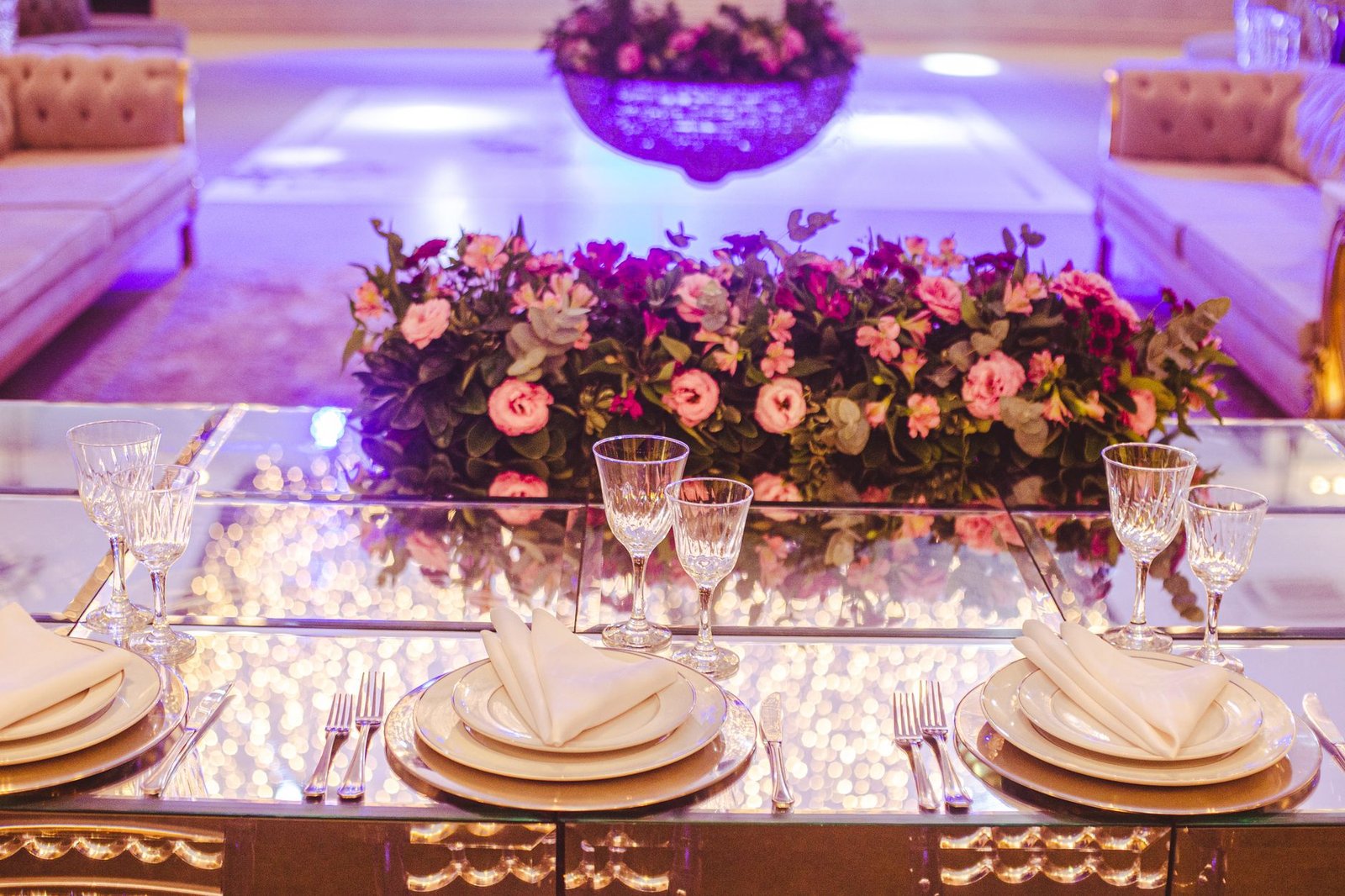 Luxurious dining table setting with elegant floral centerpiece and crystal glassware.