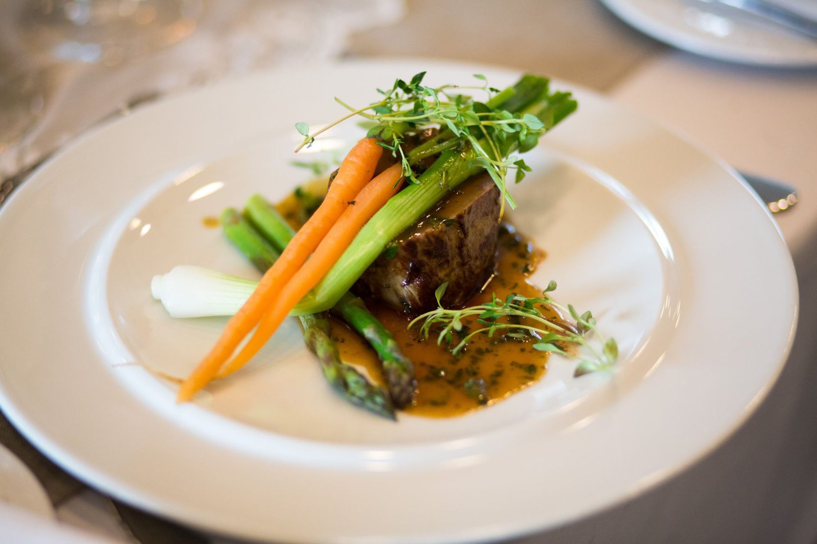 Luxurious gourmet meal elegantly plated with vegetables and sauce.
