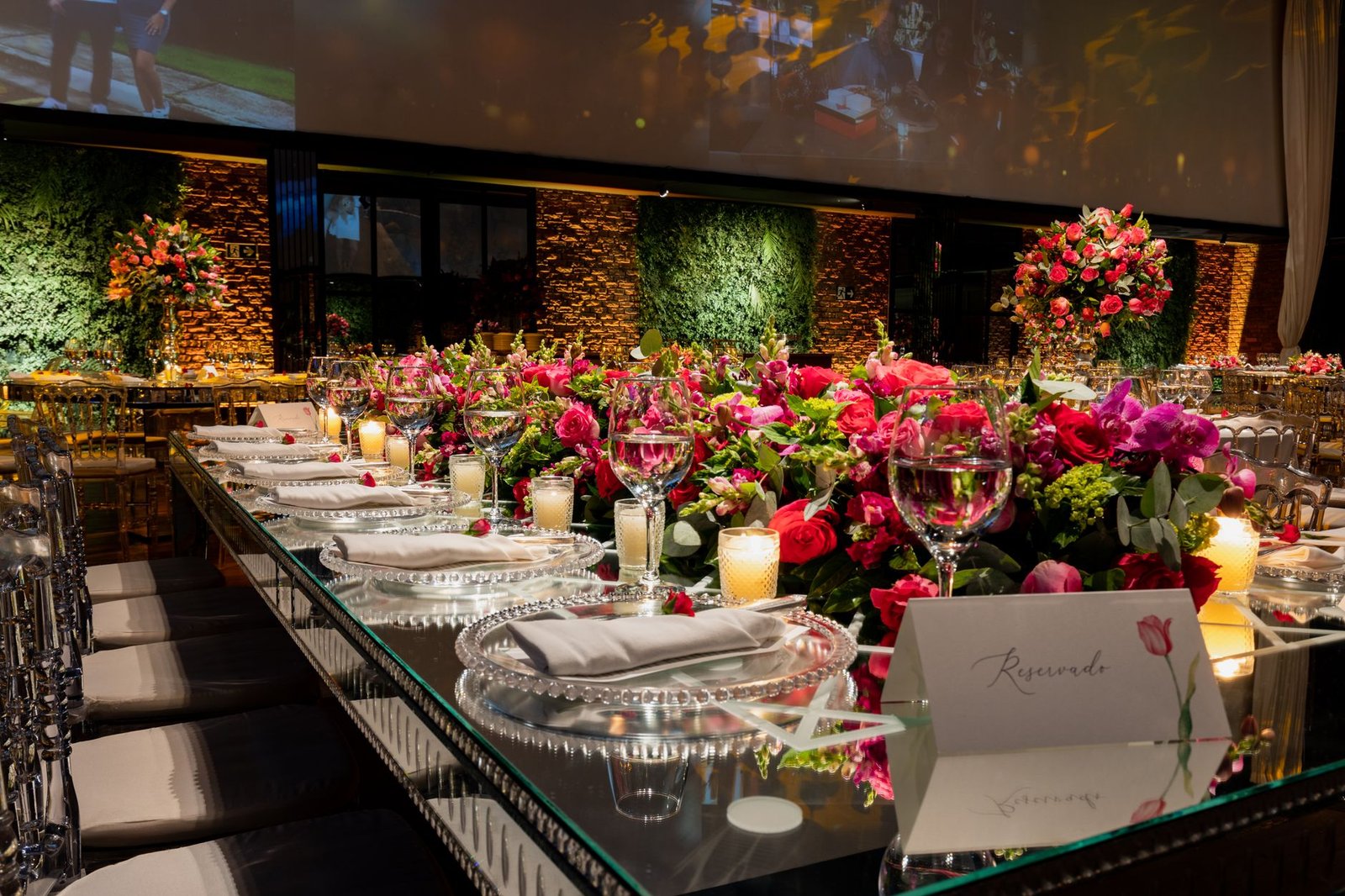 Luxurious wedding reception table setting with lavish floral decorations and candles.