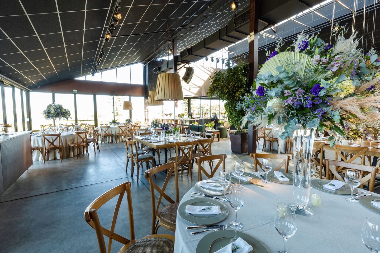 Spacious wedding venue featuring floral decor, elegant table settings, and rustic charm.