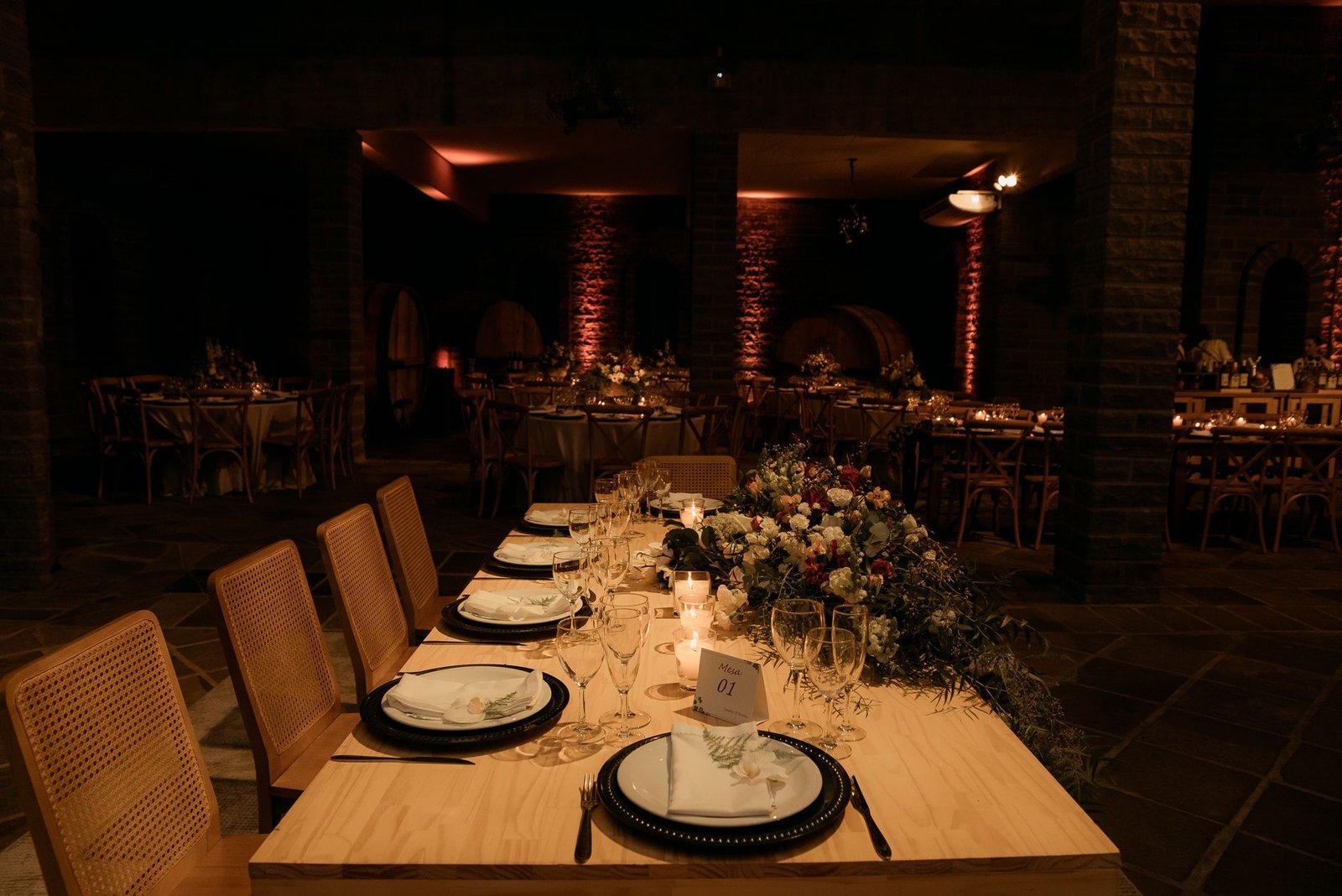 A beautifully arranged wedding reception table with floral decor and soft candlelight ambiance.