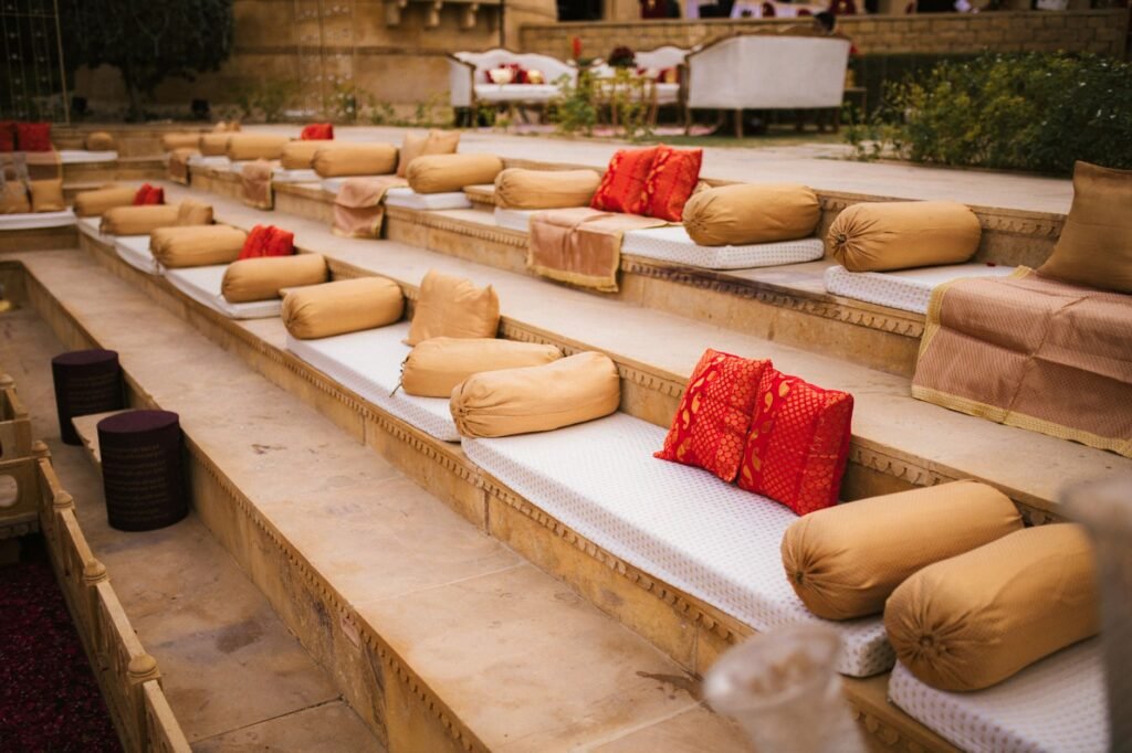 Elegant outdoor seating arrangement with vibrant cushions on a terraced platform, creating a warm and inviting atmosphere.