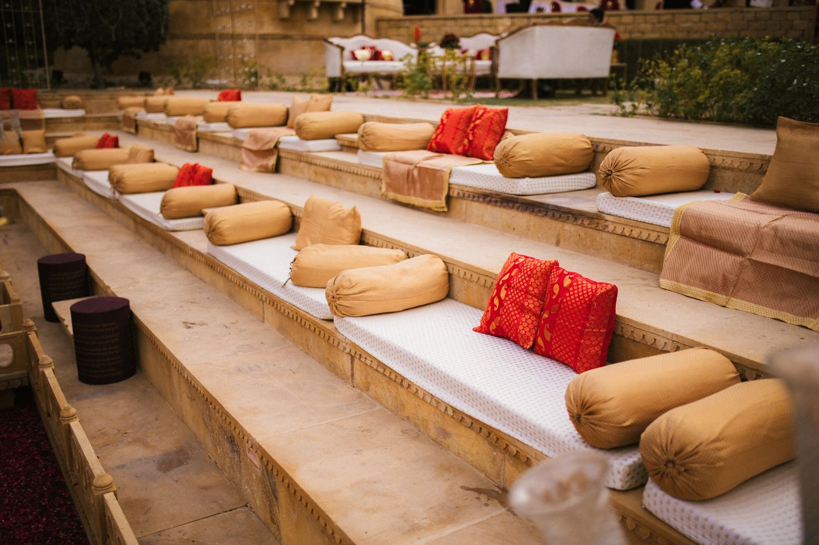 Elegant outdoor seating arrangement with vibrant cushions on a terraced platform, creating a warm and inviting atmosphere.
