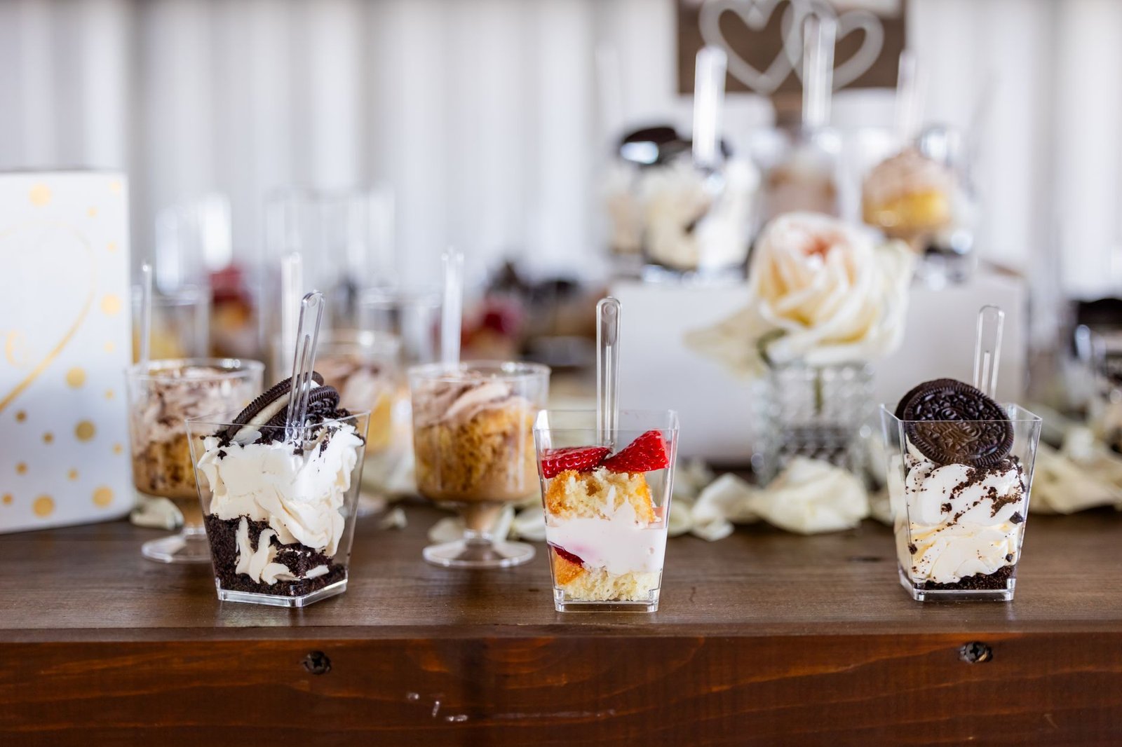 Elegant dessert table featuring mini parfaits and cupcakes, perfect for events.