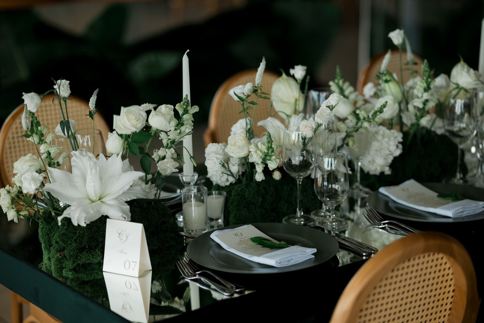 Beautifully decorated wedding reception table with white floral centerpiece and glassware.