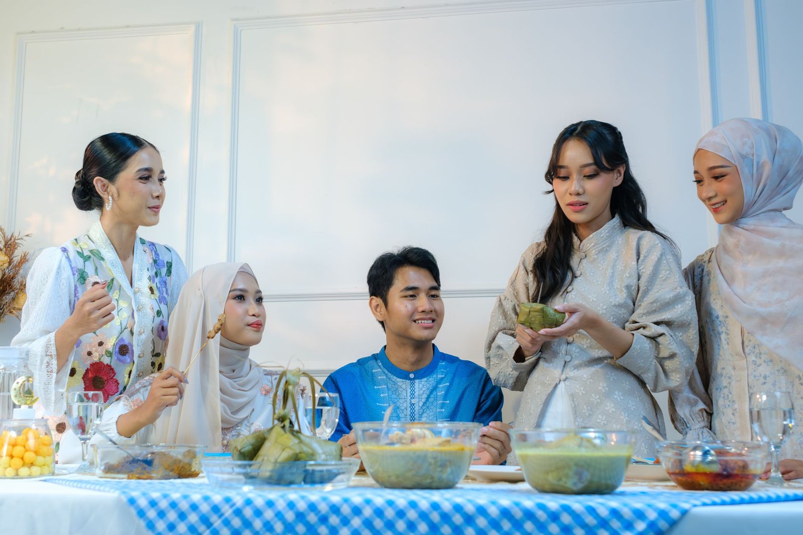 A group of adults enjoying a traditional meal together during Eid in Jakarta.