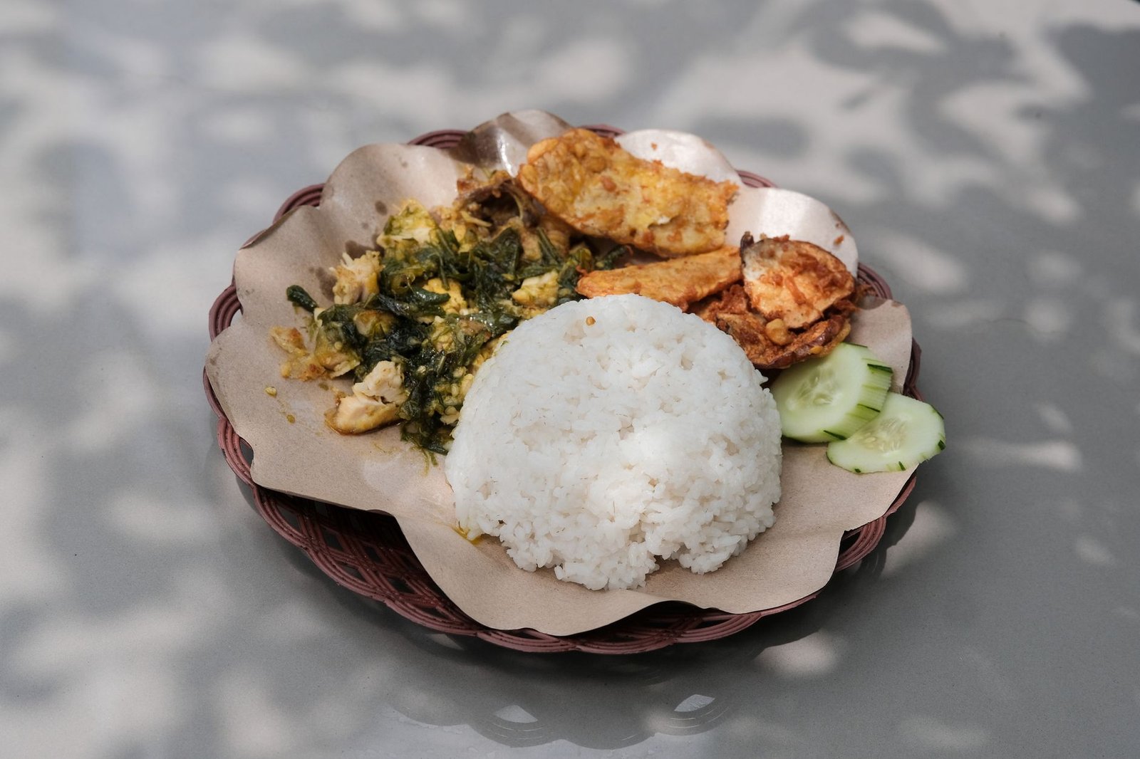 Savor the authentic taste of Indonesian Nasi Padang, featuring rice and assorted vegetables under natural light.