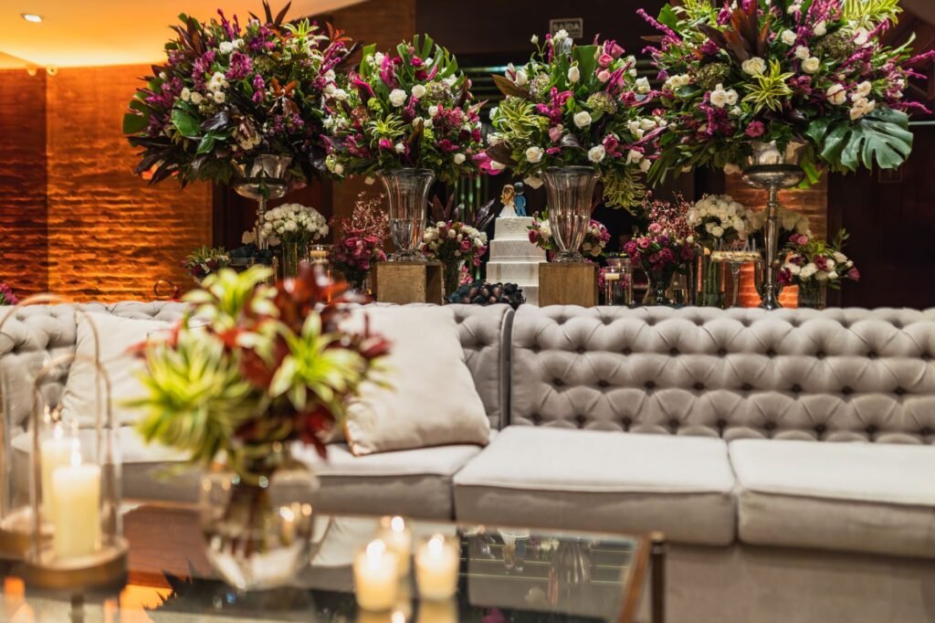 Susunan bunga mewah dan lilin di foyer resepsi pernikahan yang elegan.