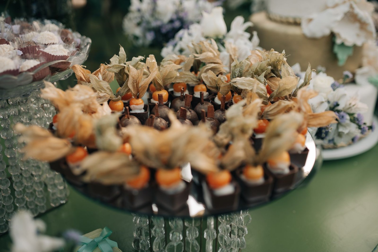 Makanan penutup yang disajikan dengan indah dengan physalis dan cokelat di resepsi pernikahan.