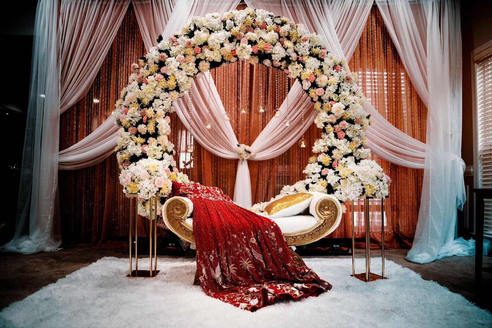 Luxurious wedding stage featuring a floral arch and traditional attire, ideal for ceremonies.
