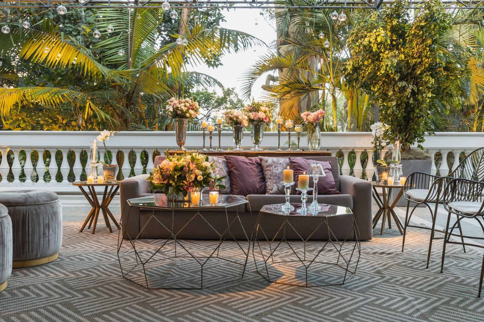 Luxurious outdoor terrace decorated with flowers, candles, and elegant furniture.