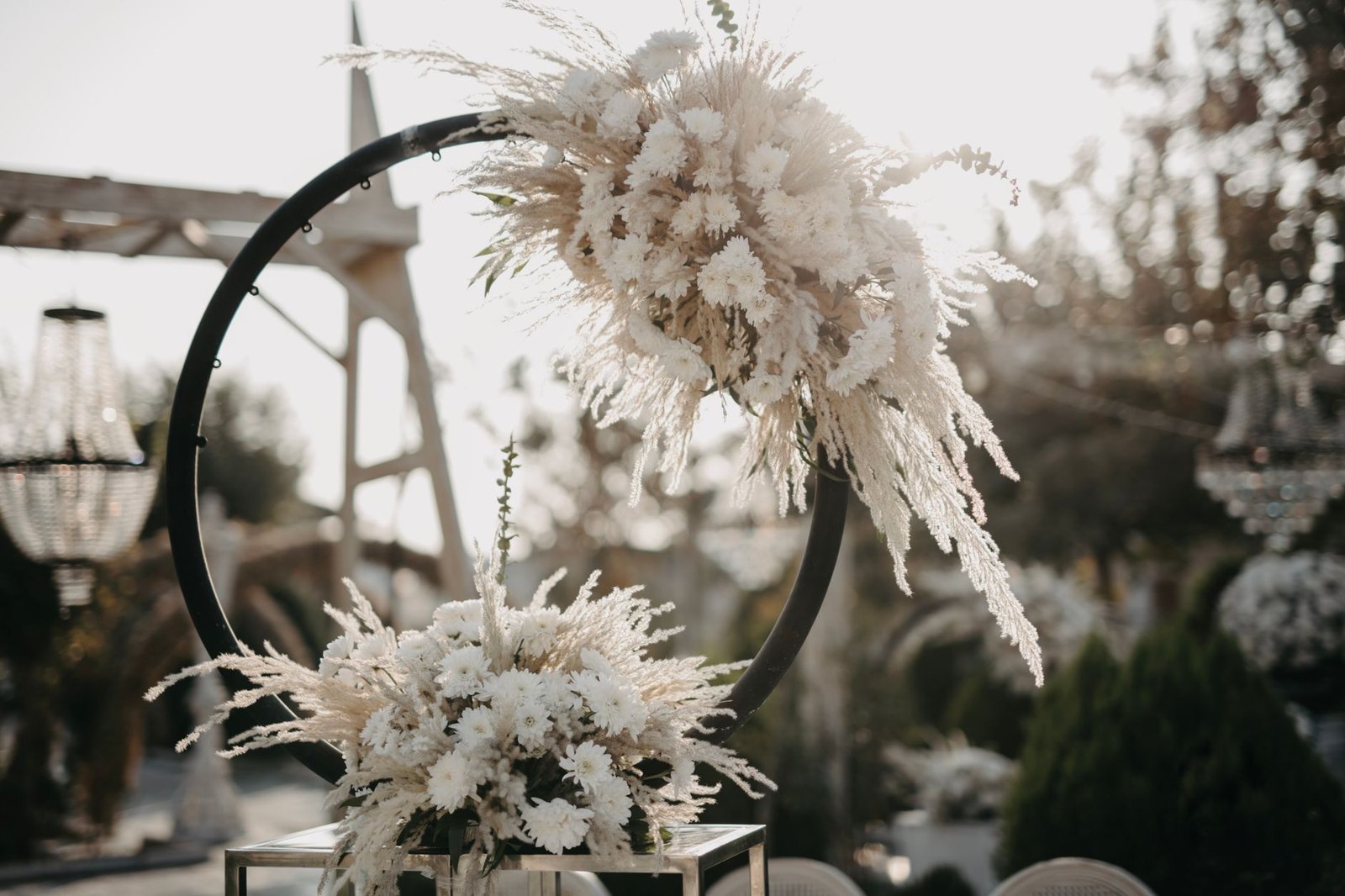Beautiful floral arrangement with pampas grass and white flowers at an outdoor wedding setting.