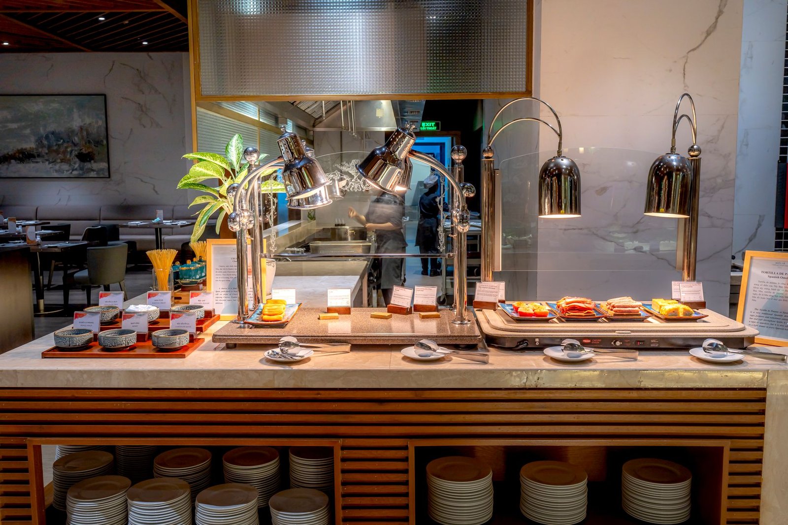Elegant buffet setup in a modern restaurant with stylish tableware and lighting.