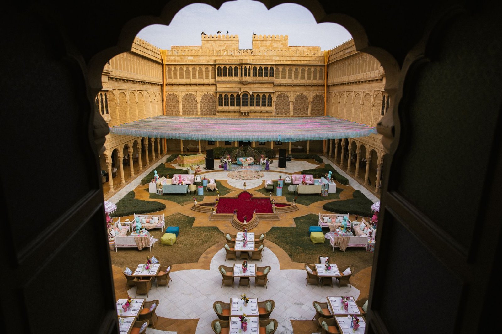 A beautifully arranged wedding setup in an Indian palace courtyard, captured from above.