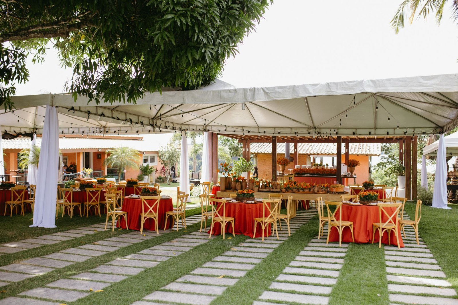 Charming outdoor wedding reception under a canopy with vibrant decor and seating.
