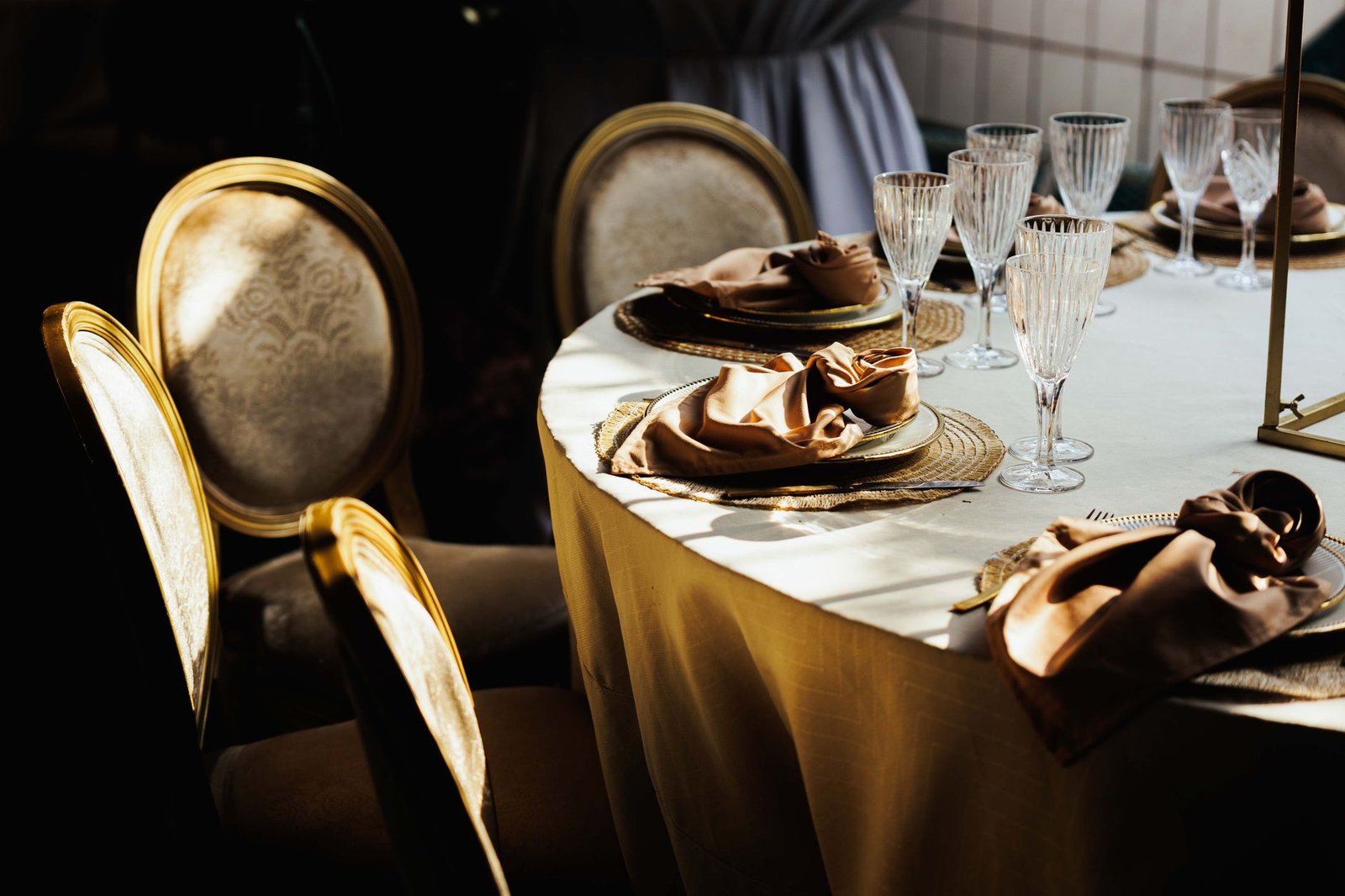Sophisticated wedding table setup featuring luxurious chairs and crystal glassware.