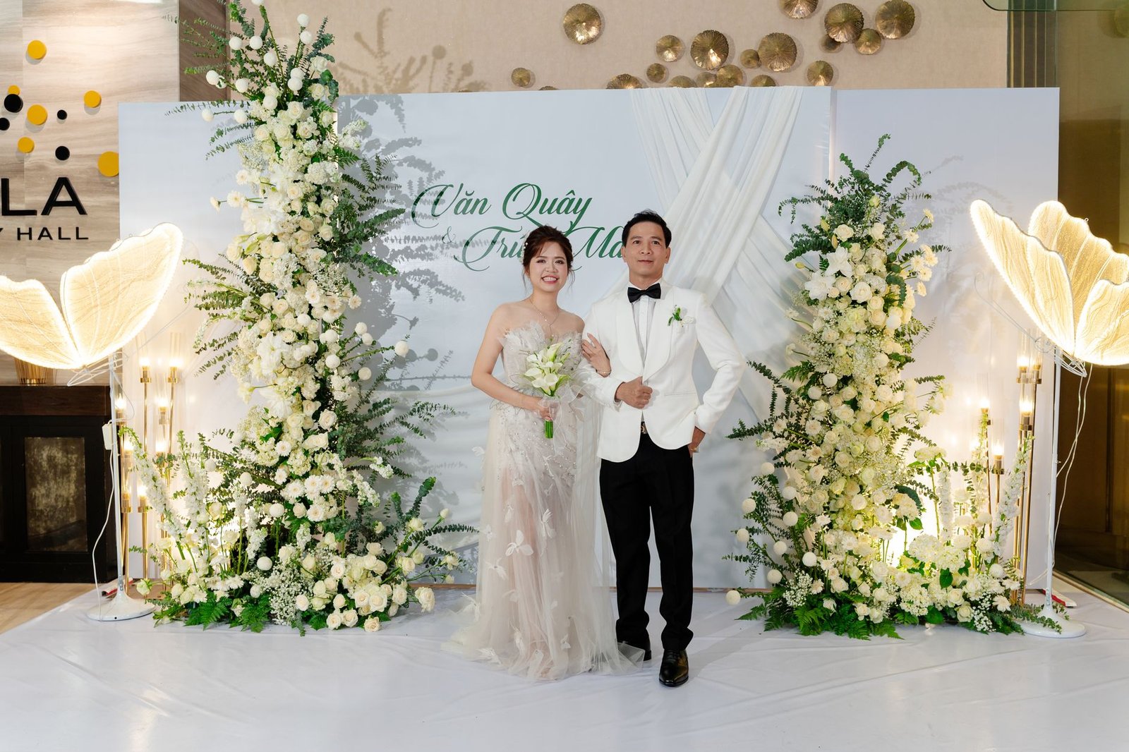 Bride and groom posing at a beautifully decorated indoor wedding venue in Hồ Chí Minh, Việt Nam.